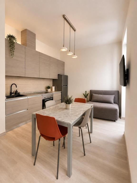 Living area with kitchen, dining table and sofa at Casa dei Greghi